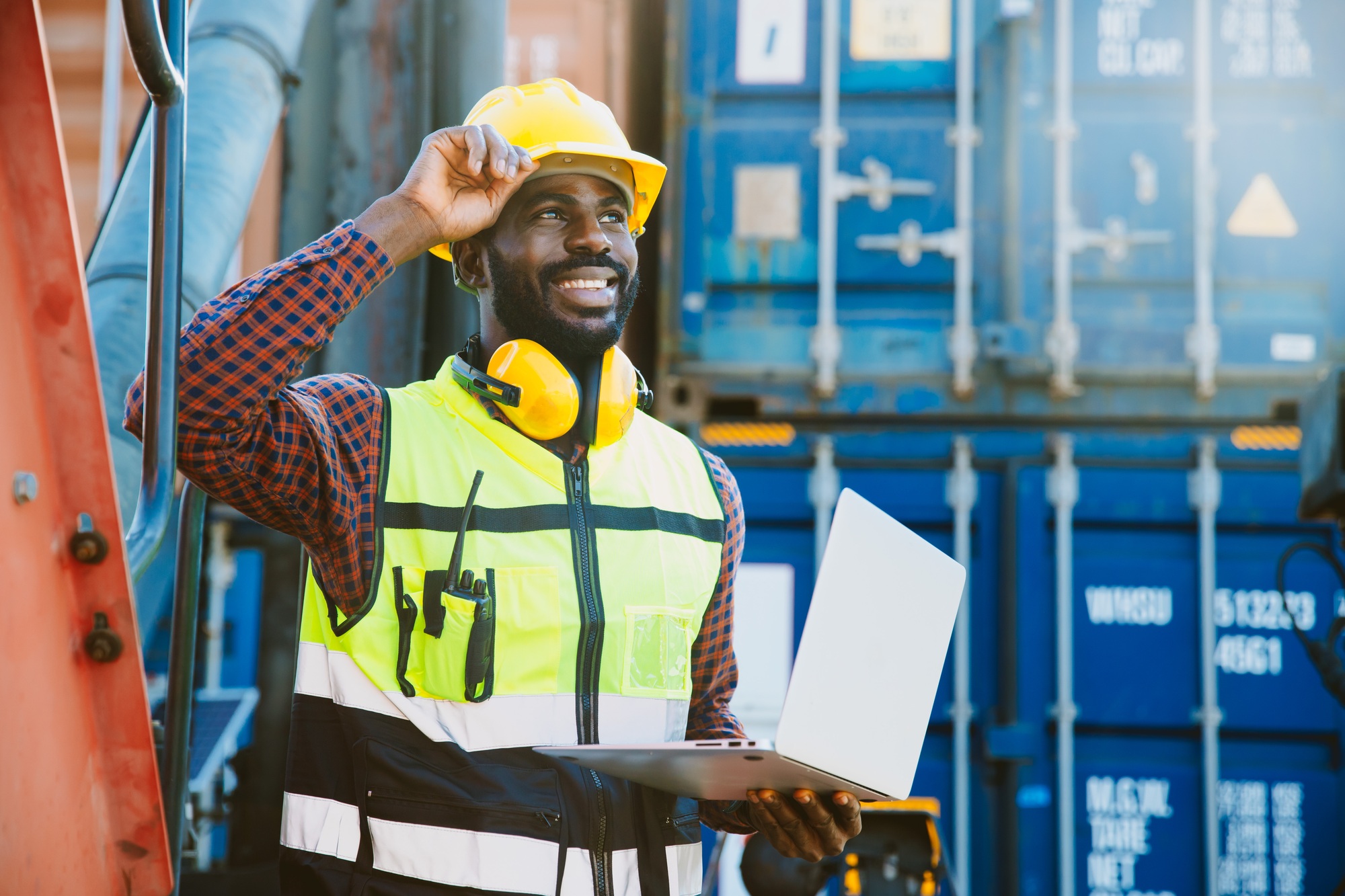 black worker African working engineer foreman in port cargo shipping with computer laptop