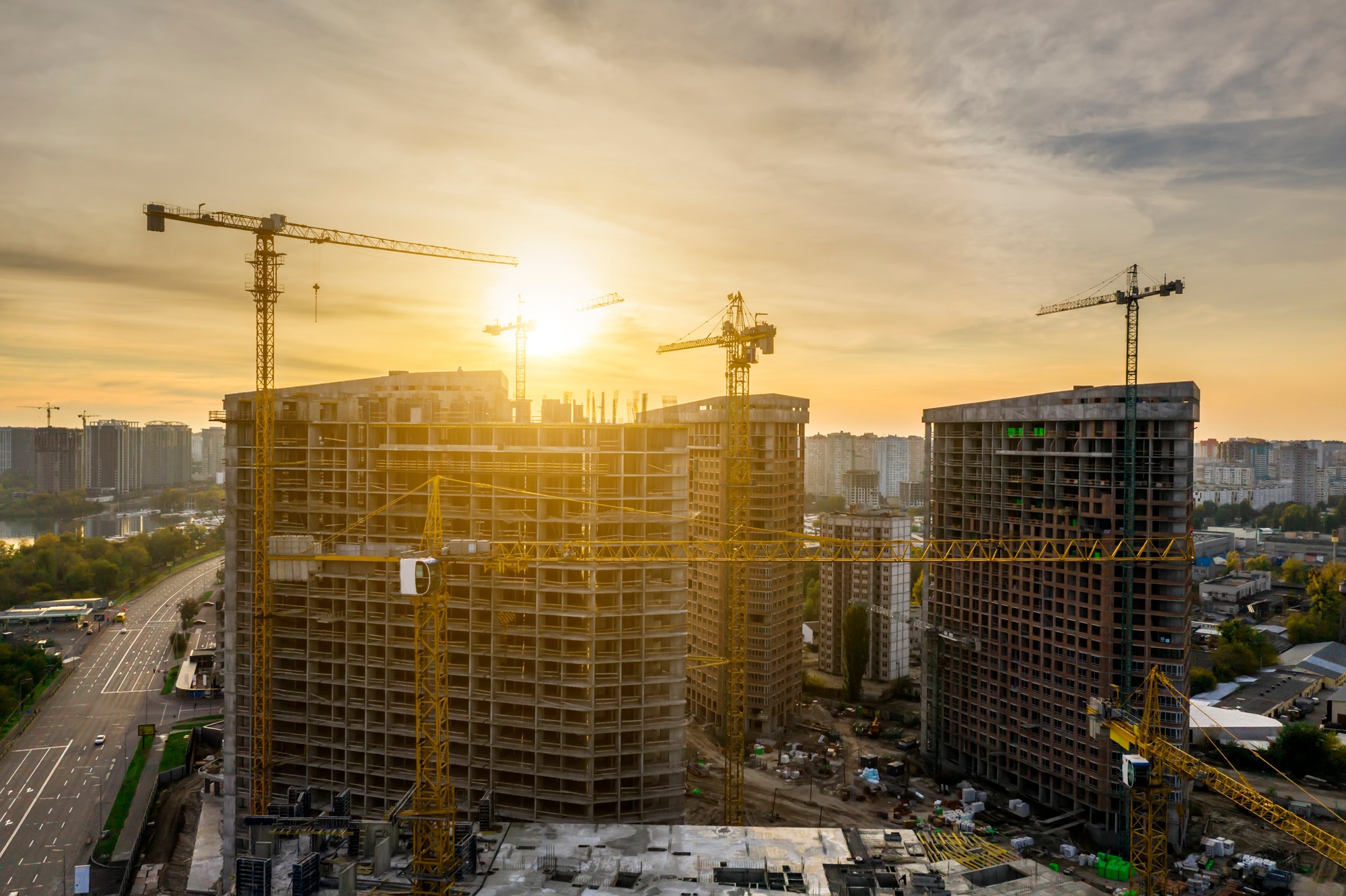 Construction site with cranes at sunset. Construction of an apartment building